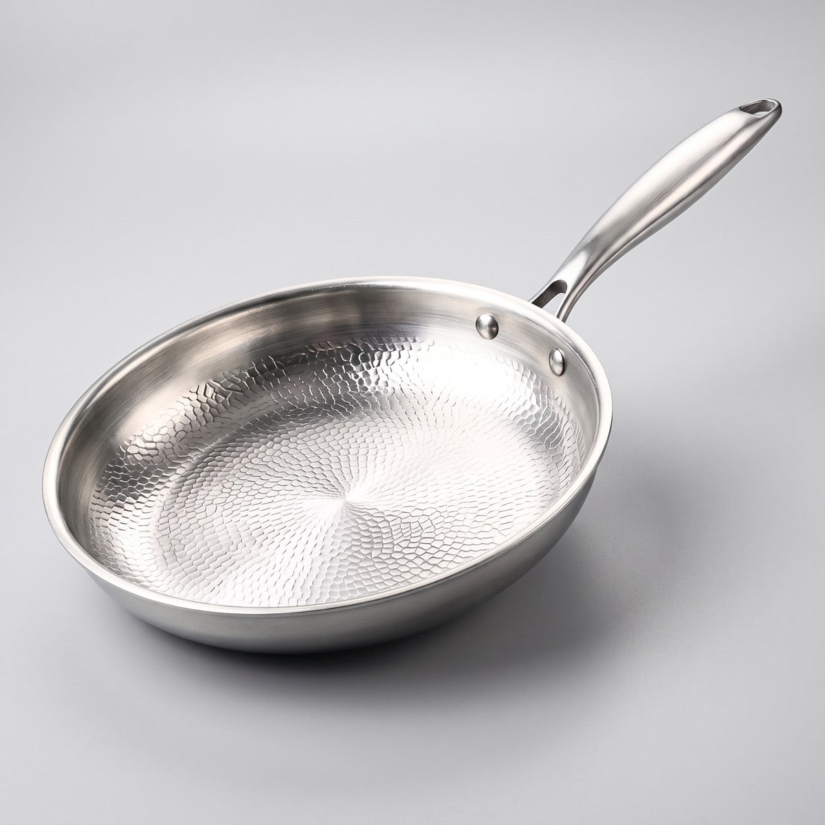 Poêle à surface de cuisson en titane martelée, sur fond gris